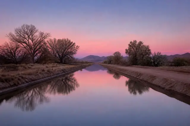 Concrete-lined irrigation canal cutting across desert flats in the Northwest Valley