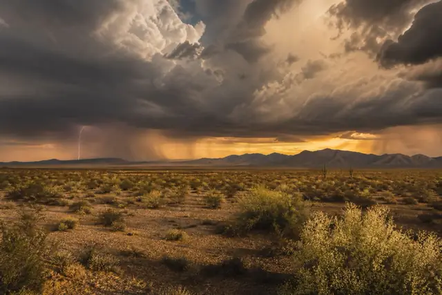 Towering monsoon storm building over the Hieroglyphic Mountains with dust haze below